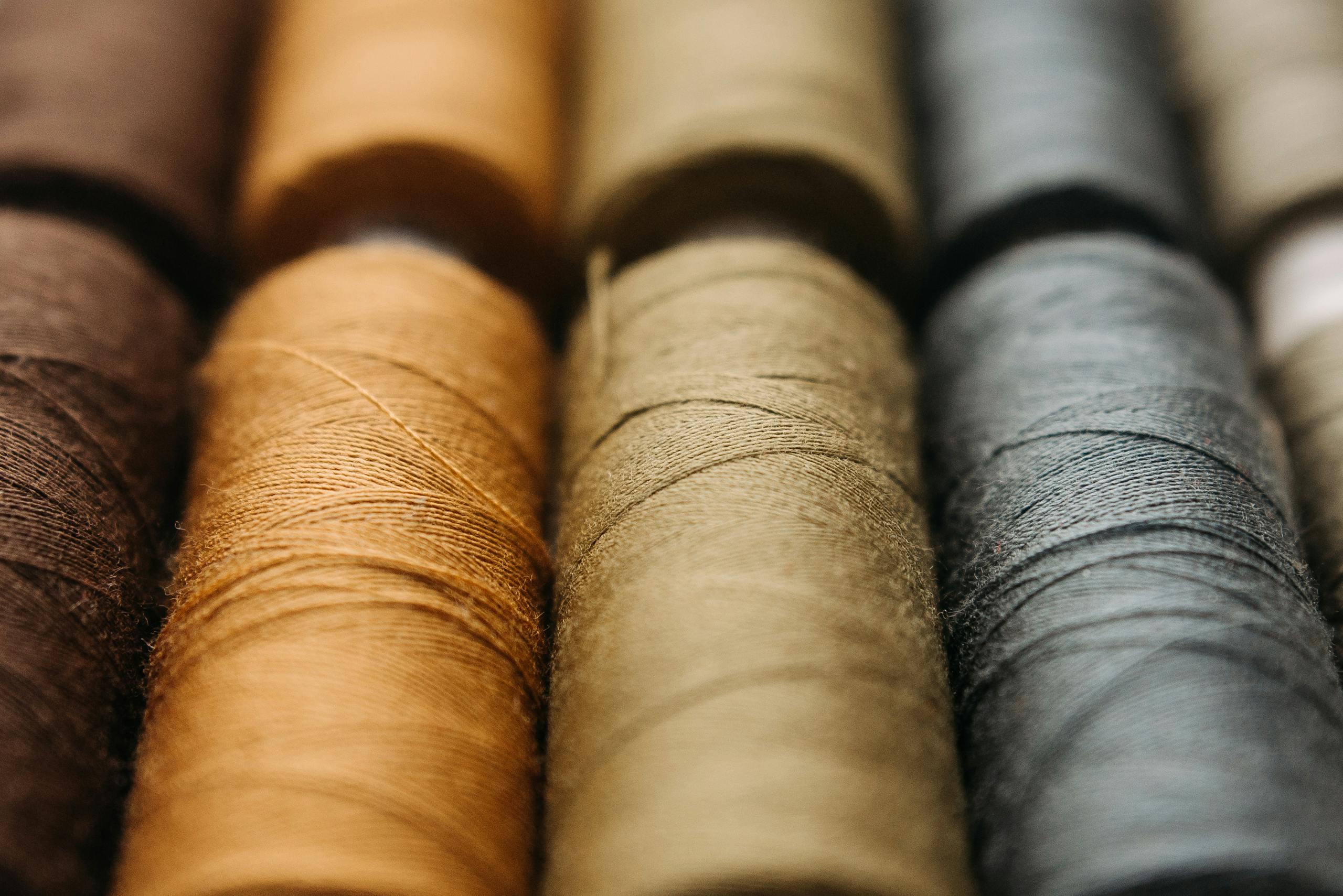 Close-up photo of various colored spools of thread ideal for sewing and crafting.
